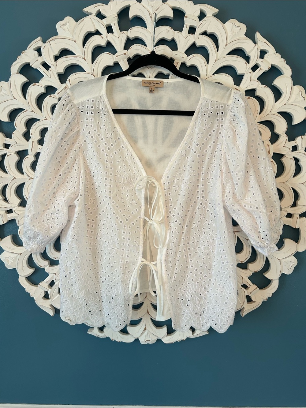 Hester & Orchard eyelet top features a front tie closure and puff sleeves.